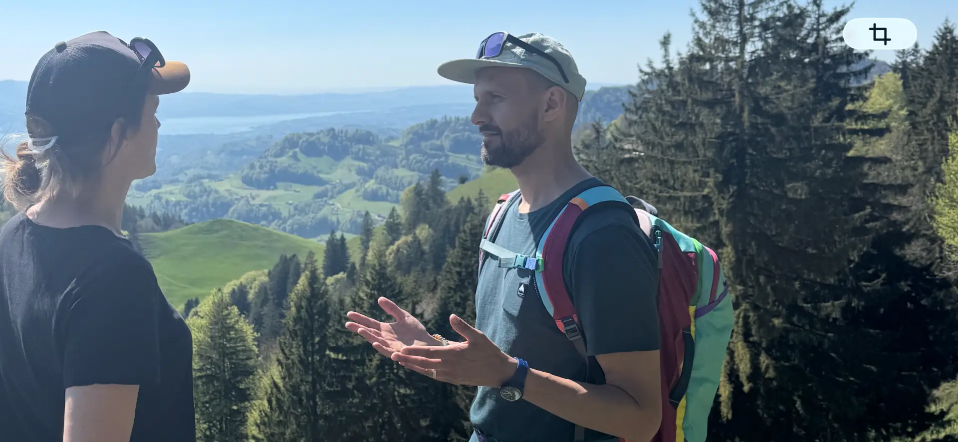 Zwei Personen im Gespräch vor Berglandschaft